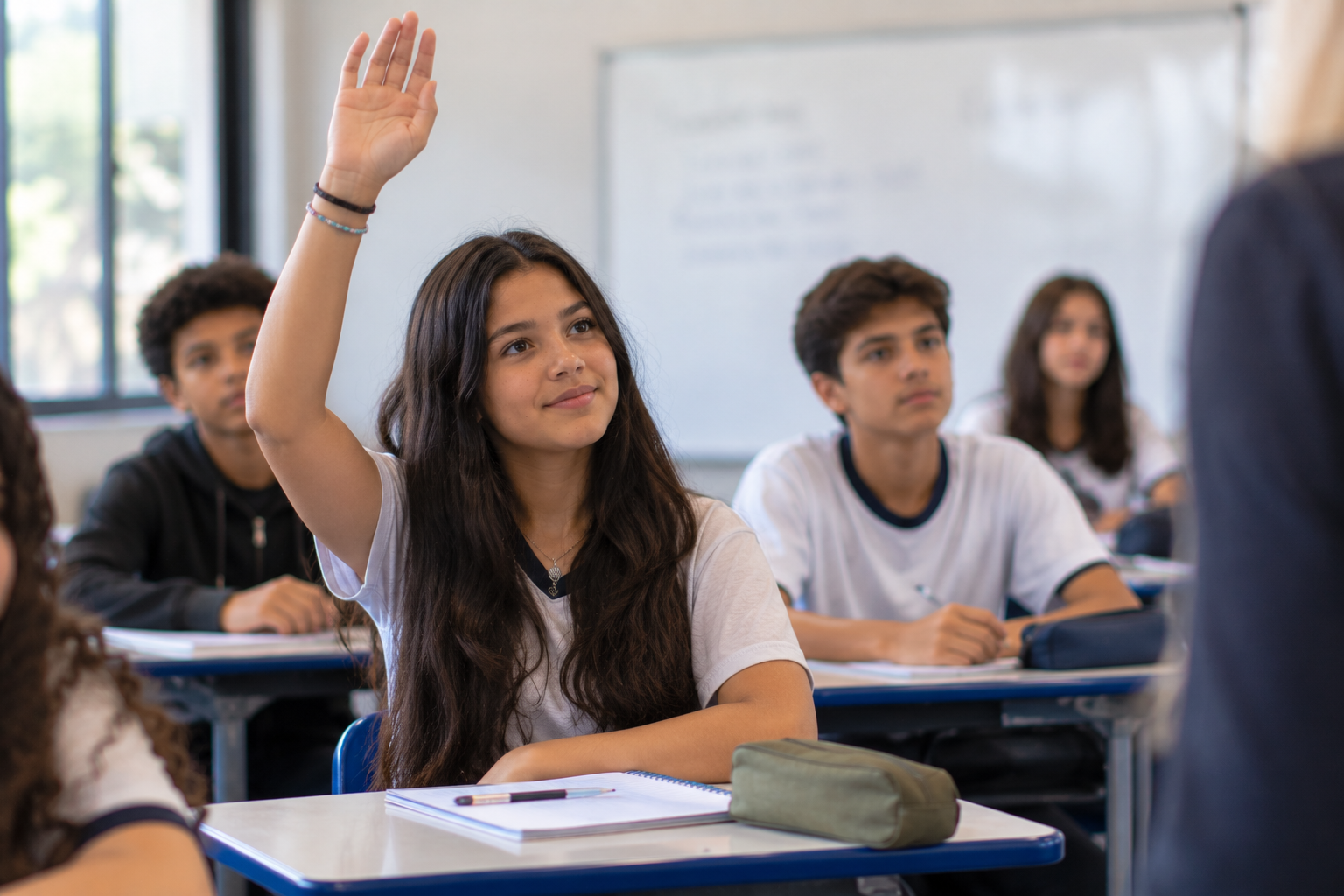 Aluna levantando a mão para fazer pergunta sobre o que não entende em aula, fator que influencia como evidência de aprendizagem.