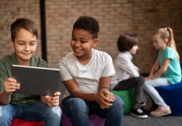 Crianças usando tablet, benefícios da inteligência artificial na educação infantil.